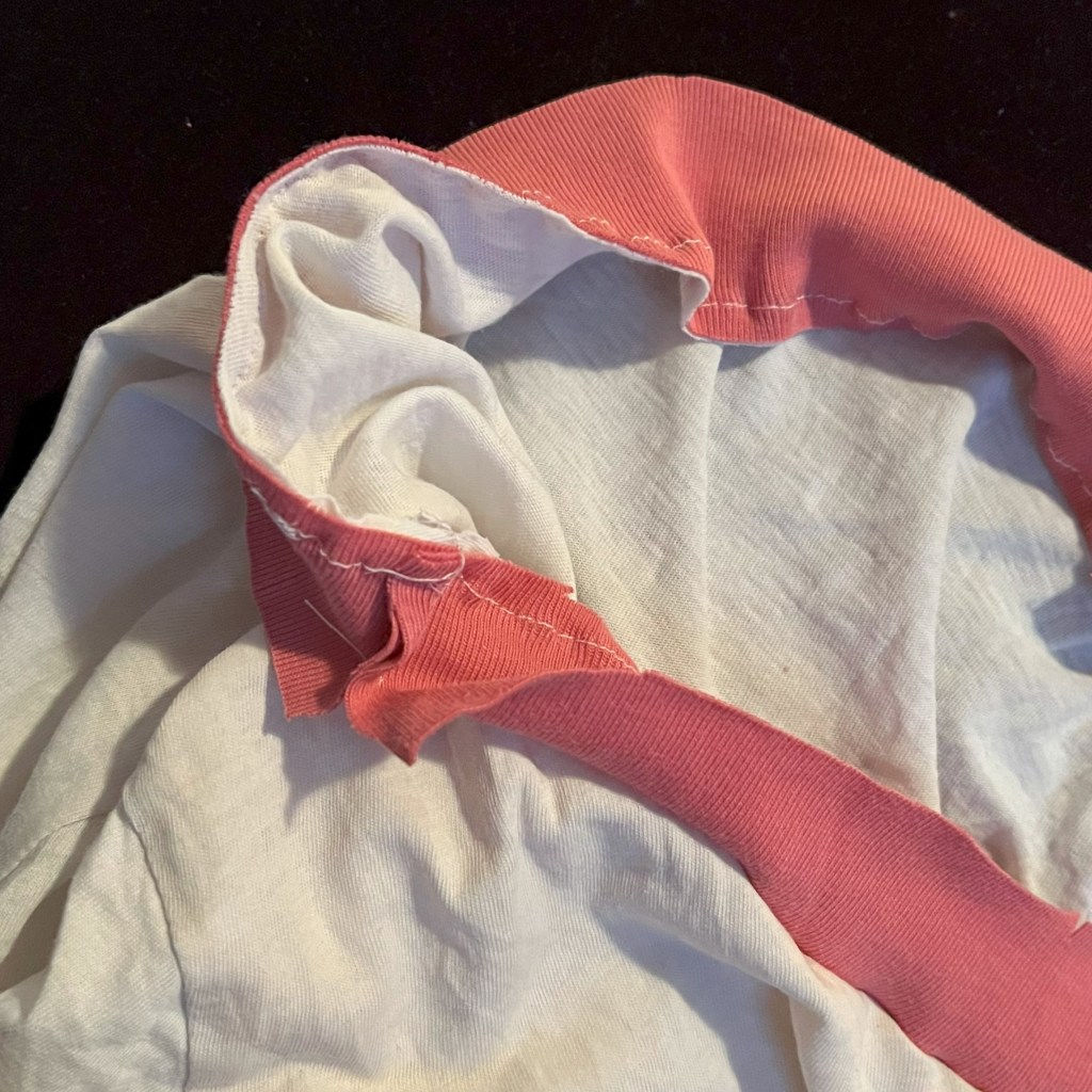 Une bande de jersey est attaché au col non fini d'un t-shirt