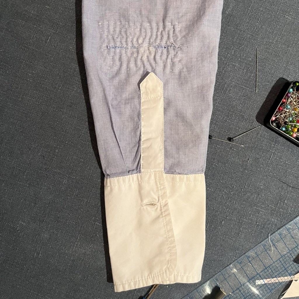 déchirure de coude de chemise réparée avec une patch intérieure